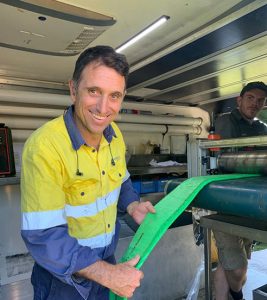 A happy pipe relining company employee with a flat hose