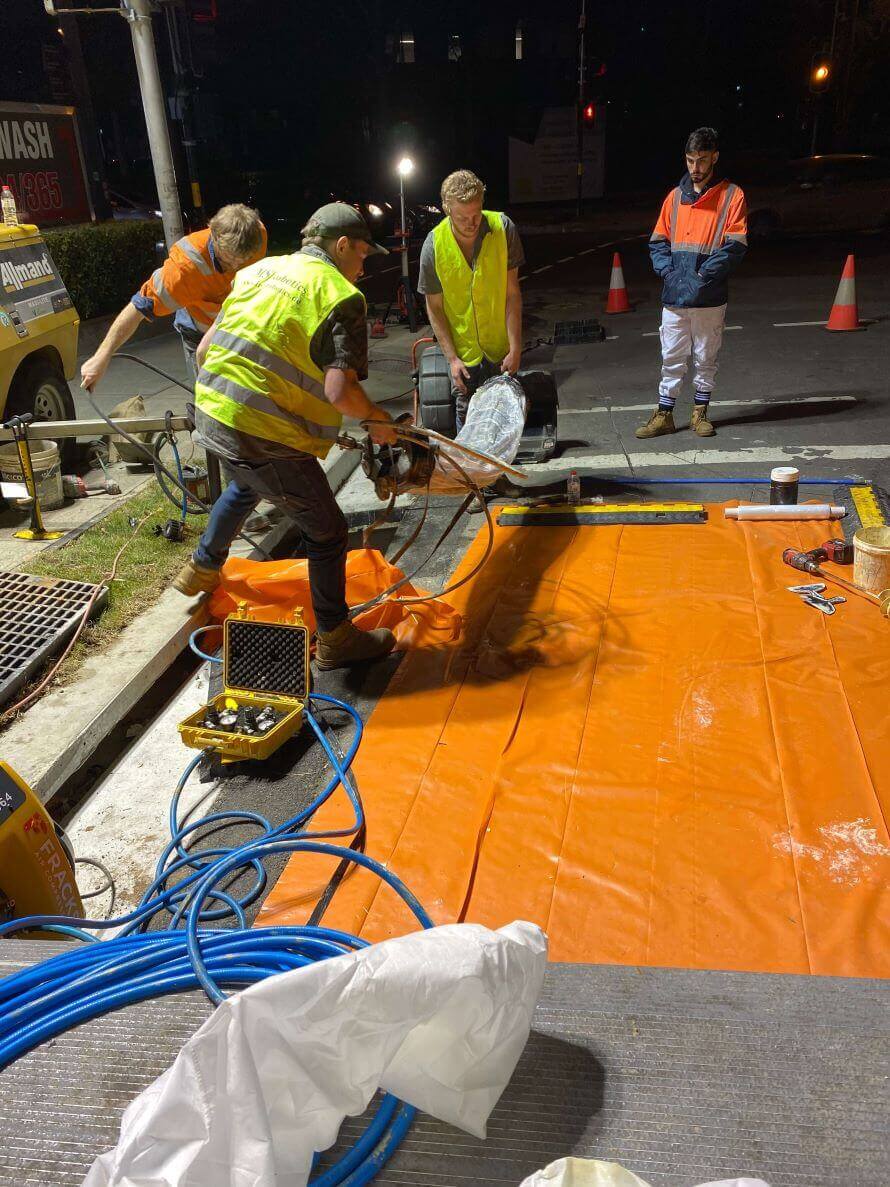 A group of The Relining Employees working on relining a pipe at night