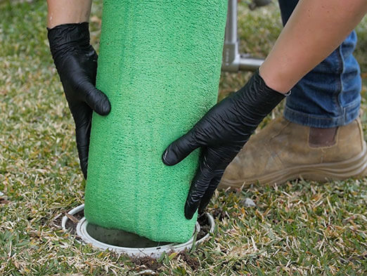 Hands putting a lining down an outdoor drain