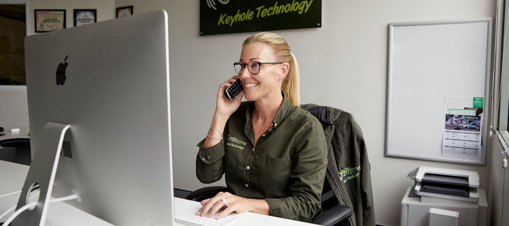 A relining company employee smiling and answering the phone in an office