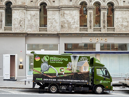 A Relining Company Truck outside of a pretty building