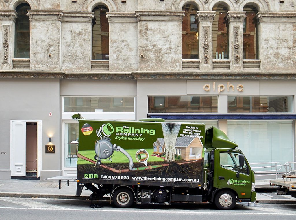 The Relining Company truck parked outside of an old stone building