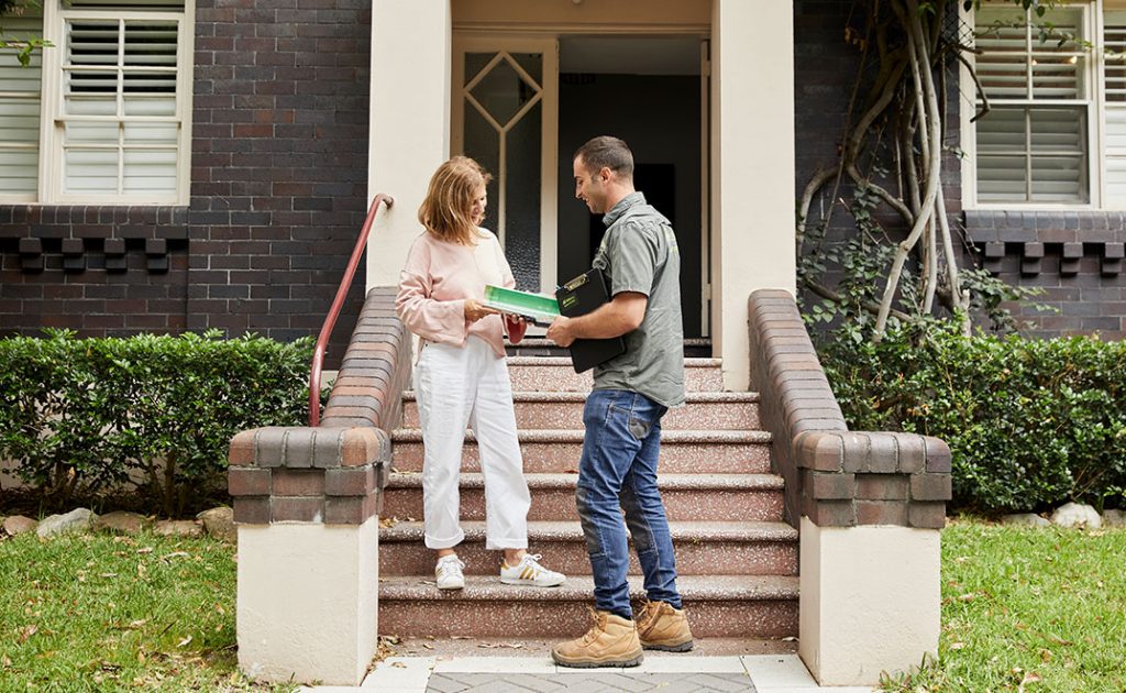 A happy man helping a happy woman on steps