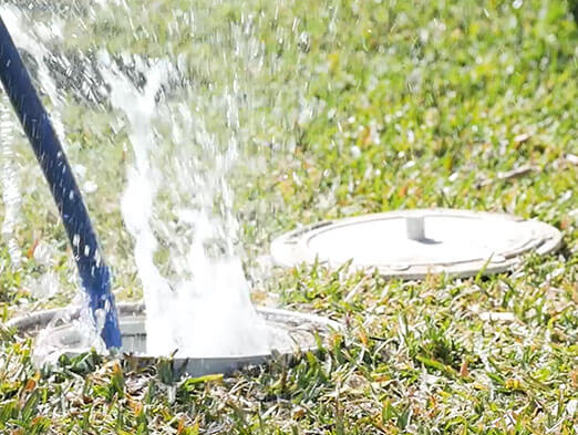 An outdoor drain splashing up