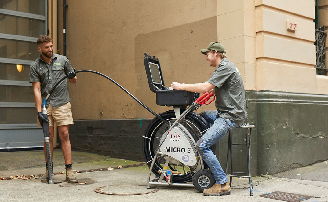 Two Pipe Relining Company Members Happily working on a drain