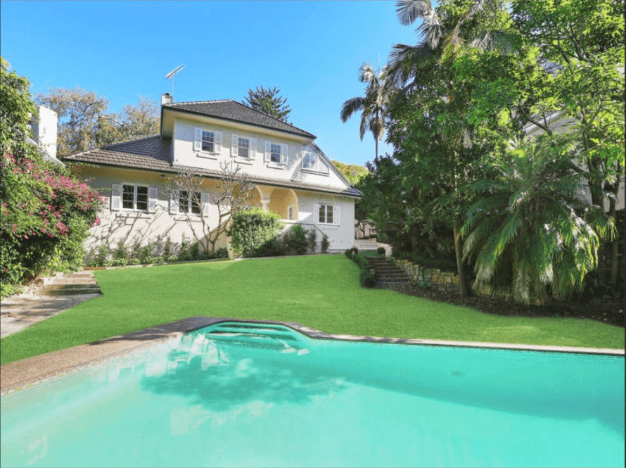 A white house with palm trees and a pool