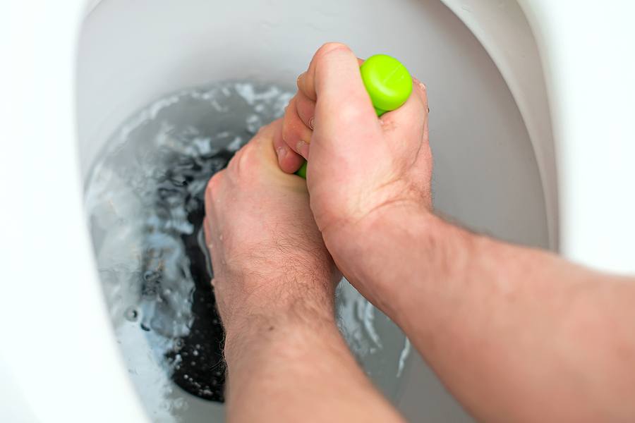 man using toilet plunger