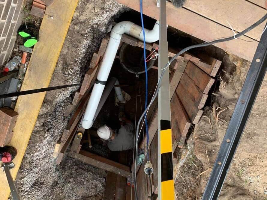 A pipe relining employee going underground with pipes