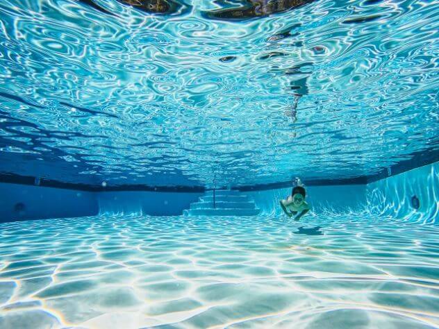 Kid swimming under pool water