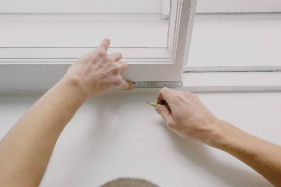 Hands measuring a widow to replace it