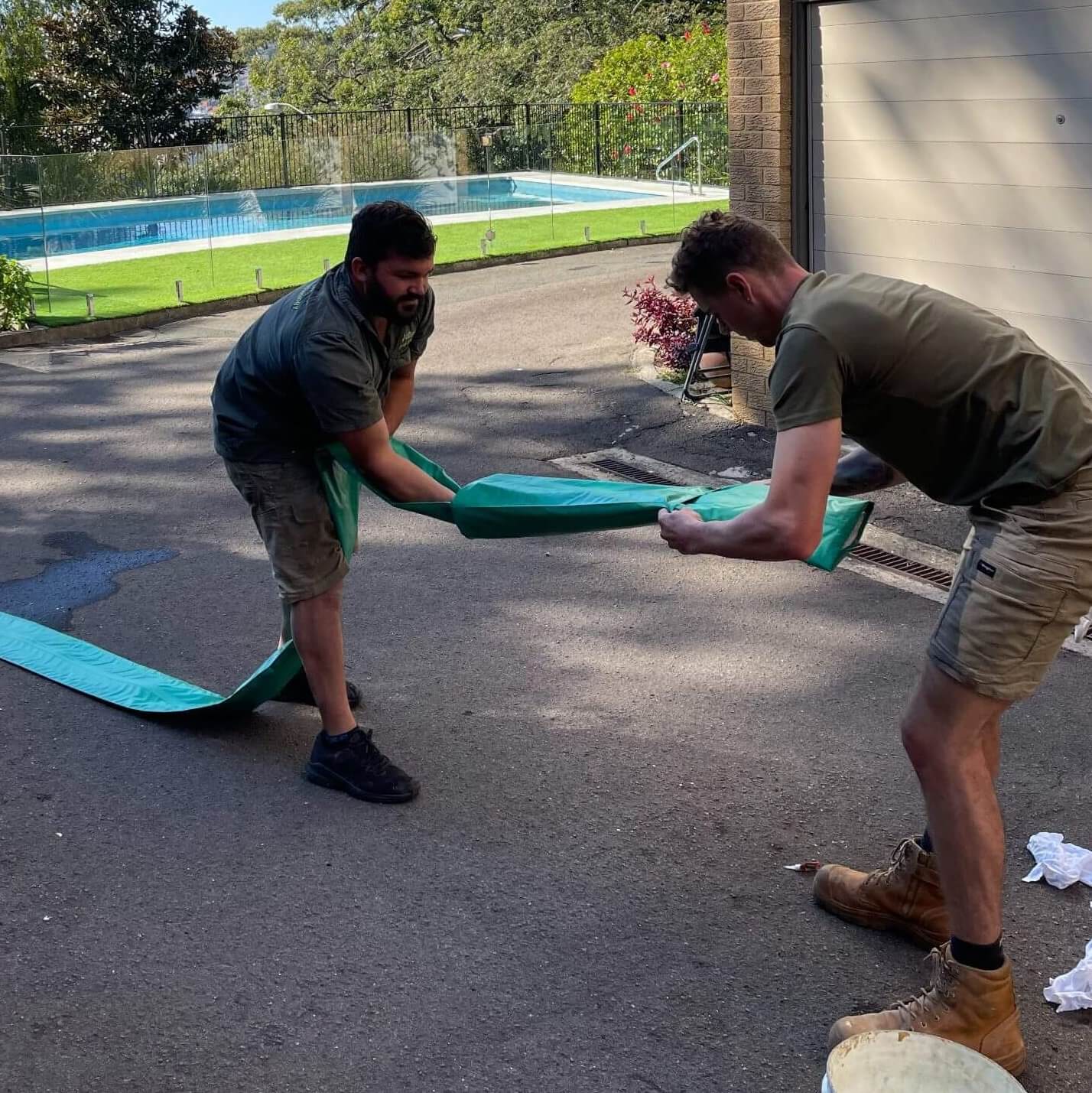 Two pipe-relining experts fixing a blocked pool drain