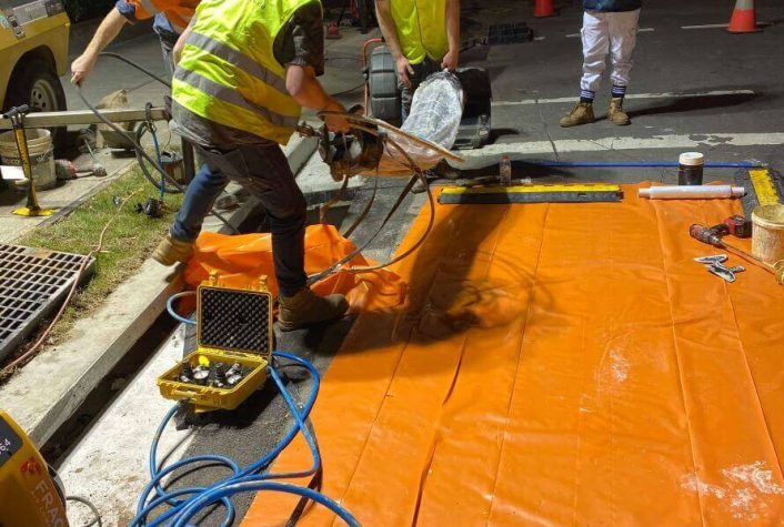 A group of The Relining Employees working on relining a pipe at night