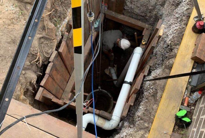 A pipe relining employee going underground with pipes